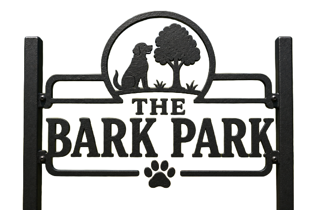 A black metal sign displays The Bark Park with a dog, tree, and paw print design above and below the text.